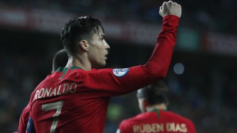 Portugal's Cristiano Ronaldo celebrates after scoring the opening goal during the Euro 2020 group B qualifying soccer match between Portugal and Lithuania at the Algarve stadium outside Faro, Portugal, Thursday, Nov. 14, 2019. (AP Photo/Armando Franca)