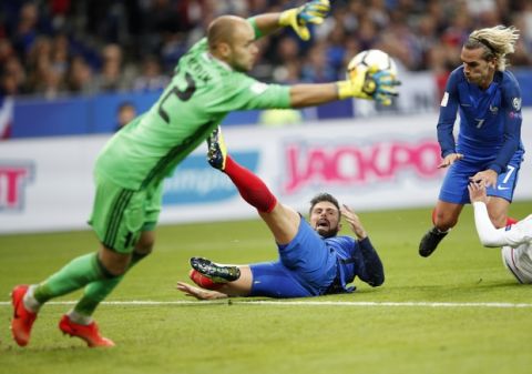 Belarus' goalkeeper Sergei Chernik saves a goal as France's Olivier Giroud , center, and France's Antoine Griezmann fall down during the World Cup Group A qualifying soccer match between France and Belarus at the Stade de France stadium in Saint-Denis, outside Paris, Tuesday, Oct.10, 2017. (AP Photo/Christophe Ena)