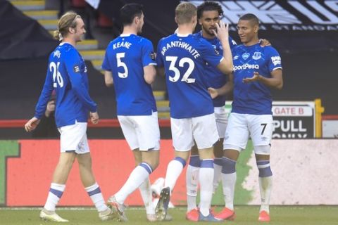 Everton's Richarlison (7) is congratulated by teammates after scoring a goal against Sheffield United during the English Premier League soccer match between Sheffield United and Everton at Bramall Lane in Sheffield, England, Monday, July 20, 2020. (AP Photo/Peter Powell, Pool)