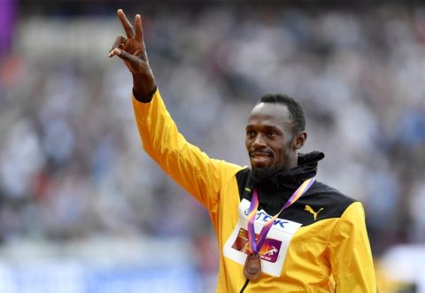 Bronze medalist Jamaica's Usain Bolt waves from the podium following the medal ceremony for the Men's 100 meters during the World Athletics Championships in London Sunday, Aug. 6, 2017. (AP Photo/Martin Meissner)