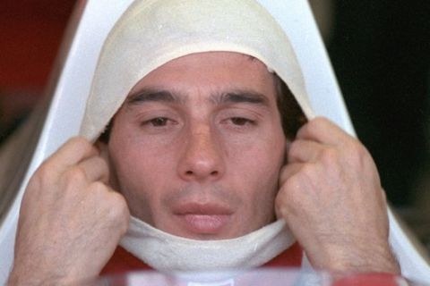FILE - In this November 4, 1989, file photo, Brazilian driver Ayrton Senna, in a McLaren Honda, pulls on a fire resistant mask before going out to practice for the Australian Grand Prix. Senna won three Formula One titles  in 1988, 1990 and '91  all with McLaren. He moved to the Williams team for his tragic 1994 season. Despite his career being cut short when he was 34, his 41 wins stand third all-time behind Michael Schumacher's 91 and rival Alain Prost's 51. He died at the 1994 San Marino Grand Prix. (AP Photo/Stephan Holland, File)