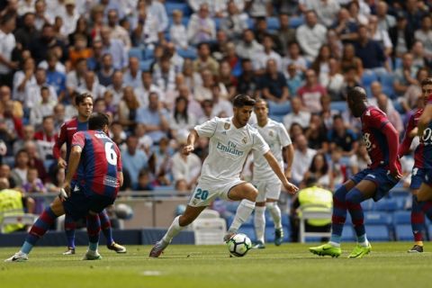 Real Madrid's Marco Asensio, centre, controls the ball past Levante defenders during the Spanish La Liga soccer match between Real Madrid and Levante at the Santiago Bernabeu stadium in Madrid, Saturday, Sept. 9, 2017. (AP Photo/Francisco Seco)