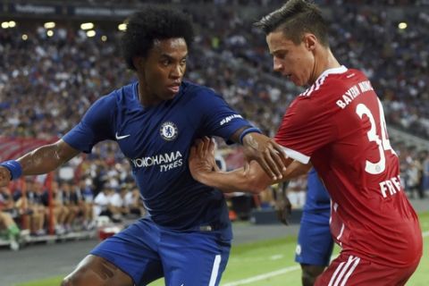 Willian of Chelsea, left, and Marco Friedl of Bayern Munich vie for the ball during the International Champions Cup 2017 match between soccer clubs Bayern Munich from Germany and Chelsea of England , Tuesday, July 25, 2017 in Singapore. (AP Photo/Joseph Nair)