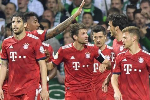 Bayern players celebrate with Robert Lewandowski, third from right, after he scored his side's first goal during the German soccer cup, DFB Pokal, semifinal match between Werder Bremen and Bayern Munich at the Weser stadium in Bremen, Germany, Wednesday, April 24, 2019. (AP Photo/Martin Meissner)