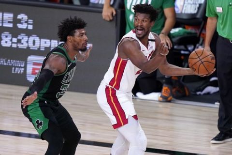 Boston Celtics guard Marcus Smart (36) defends as Miami Heat forward Jimmy Butler (22) instructs the offense during the second half of an NBA conference final playoff basketball game, Thursday, Sept. 17, 2020, in Lake Buena Vista, Fla. Celtics head coach Brad Stevens, top right, looks on during the play. (AP Photo/Mark J. Terrill)