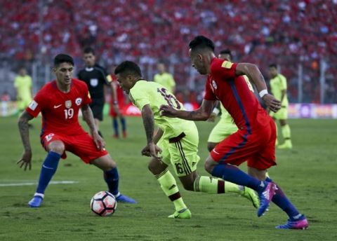 Venezuela's Darwin Machis, center, fights for the ball with Chile's Pedro Hernandez, left, and Mauricio Isla, right, during a 2018 World Cup qualifying soccer match in Santiago, Chile, Tuesday, March 28, 2017. (AP Photo/Esteban Felix)