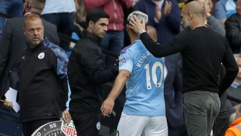 Manchester City's head coach Pep Guardiola, right, speaks with Manchester City's Sergio Aguero during the English Premier League soccer match between Manchester City and Tottenham Hotspur at Etihad stadium in Manchester, England, Saturday, Aug. 17, 2019. (AP Photo/Rui Vieira)