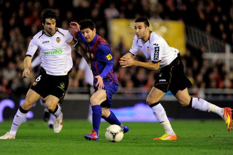 Valencia's French defender Adil Rami (R) and Valencia's midfielder David Albelda (L) vies with Barcelona's Argentinian forward Lionel Messi (C) during the Spanish cup semi-final match Valencia CF vs FC Barcelona at the Mestalla stadium in Valencia on February 1, 2012.  AFP PHOTO/ JOSEP LAGO (Photo credit should read JOSEP LAGO/AFP/Getty Images)