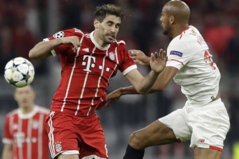 Bayern's Javi Martinez, left, and Sevilla's Steven N'Zonzi go for a ball during the Champions League quarter final second leg soccer match between FC Bayern Munich and Sevilla FC at the Allianz Arena stadium in Munich, Germany, Wednesday, April 11, 2018. (AP Photo/Matthias Schrader)