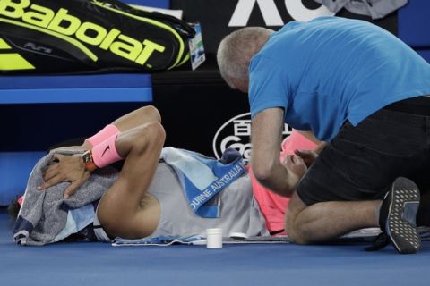 Spain's Rafael Nadal receives treatment from a trainer during his quarterfinal against Croatia's Marin Cilic at the Australian Open tennis championships in Melbourne, Australia, Tuesday, Jan. 23, 2018. (AP Photo/Dita Alangkara)