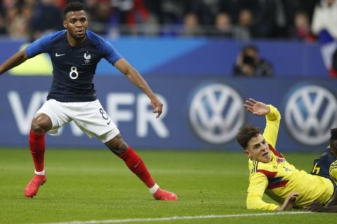 France's Thomas Lemar, left, watches as he scores his side's second goal during a friendly soccer match between France and Colombia, at the Stade de France stadium in Saint-Denis, outside Paris, France, Friday March 23, 2018. (AP Photo/Francois Mori)