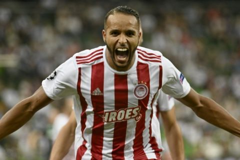 Olympiakos' Youssef El Arabi celebrates after scoring his side's second goal during the Champions League qualifying playoff second leg soccer match between Olympiakos and Krasnodar in Krasnodar, Russia, Tuesday, Aug. 27, 2019. (AP Photo/str)