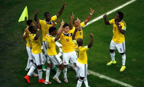 RIO DE JANEIRO, BRAZIL - JUNE 28:  James Rodriguez of Colombia celebrates scoring his team's second goal and his second of the game with teammates during the 2014 FIFA World Cup Brazil round of 16 match between Colombia and Uruguay at Maracana on June 28, 2014 in Rio de Janeiro, Brazil.  (Photo by Fabrizio Bensch - Pool/Getty Images)