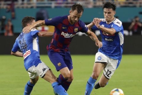 Barcelona's Ivan Rakitic, center, goes for the ball as Napoli's Dries Mertens (14) and Nikita Contini (12) defend during the first half of a soccer match Wednesday, Aug. 7, 2019, in Miami Gardens, Fla. Barcelona won 2-1. (AP Photo/Lynne Sladky)