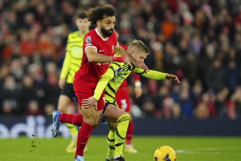 Liverpool's Mohamed Salah, left, and Arsenal's Oleksandr Zinchenko fight for the ball during the English Premier League soccer match between Liverpool and Arsenal at Anfield stadium in Liverpool, England, Saturday, Dec. 23, 2023. (AP Photo/Jon Super)