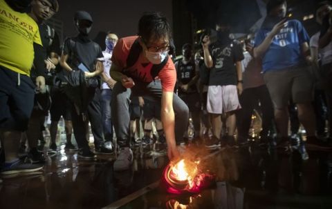 Demonstrators set a Lebron James jersey on fire during a rally at the Southorn Playground in Hong Kong, Tuesday, Oct. 15, 2019. Protesters in Hong Kong have thrown basketballs at a photo of LeBron James and chanted their anger about comments the Los Angeles Lakers star made about free speech during a rally in support of NBA commissioner Adam Silver and Houston Rockets general manager Daryl Morey, whose tweet in support of the Hong Kong protests touched off a firestorm of controversy in China. (AP Photo/Mark Schiefelbein)