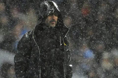 Manchester City's manager Pep Guardiola watches in heavy rain during the English Premier League soccer match between Manchester City and Watford at Etihad stadium, in Manchester, England, Tuesday, Jan. 2, 2018. (AP Photo/Rui Vieira)