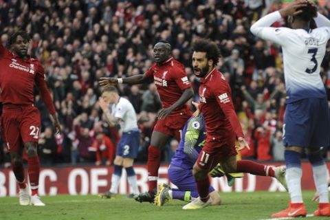 Liverpool's Mohamed Salah, center, celebrates after Tottenham's Toby Alderweireld scores an own goal past his goalkeeper during the English Premier League soccer match between Liverpool and Tottenham Hotspur at Anfield stadium in Liverpool, England, Sunday, March 31, 2019. (AP Photo/Rui Vieira)