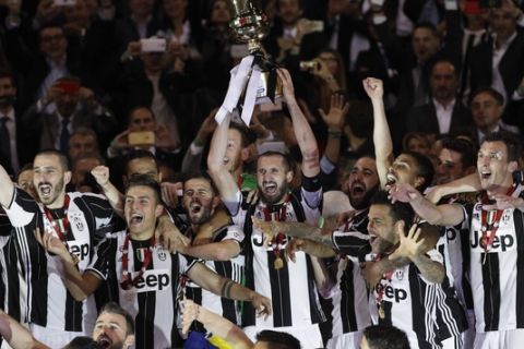 Juventus' Giorgio Chiellini holds up the trophy after winning the Italian Cup soccer final match between Lazio and Juventus, at Rome's Olympic stadium, Wednesday, May 17, 2017. Juventus won 2-0. (AP Photo/Gregorio Borgia)