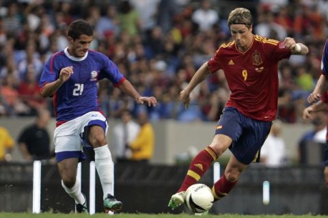 Spain s Fernando Torres, right, dribbles past Puerto Rico s Samuel Soto during a friendly soccer match in Bayamon, Puerto Rico, Wednesday, August 15, 2012. Spain won 2-1. (AP Photo/Ricardo Arduengo)