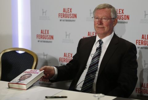 Former Manchester United manager Sir Alex Ferguson poses with his book 'My Autobiography' during a press conference in central London, Tuesday, Oct. 22, 2013. (AP Photo/Sang Tan)