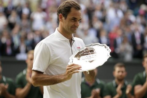 Switzerland's Roger Federer holds the runner up trophy after losing to Serbia's Novak Djokovic in the men's singles final match of the Wimbledon Tennis Championships in London, Sunday, July 14, 2019. (AP Photo/Tim Ireland)