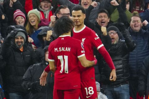 Liverpool's Cody Gakpo celebrates with Liverpool's Mohamed Salah after scoring his side's third goal during the English Premier League soccer match between Liverpool and Newcastle, at Anfield stadium in Liverpool, England, Monday, Jan. 1, 2024. (AP Photo/Jon Super)