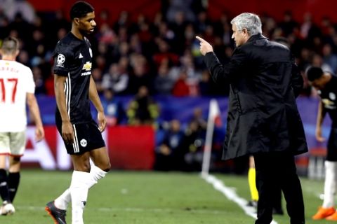 Manchester United manager Jose Mourinho talks to Manchester United's Marcus Rashford during the Champions League round of sixteen first leg soccer match between Sevilla FC and Manchester United at the Ramon Sanchez Pizjuan stadium in Seville, Spain, Wednesday, Feb. 21, 2018. (AP Photo/Miguel Morenatti)