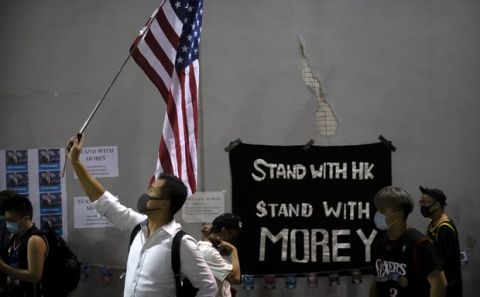A demonstrator holds a U.S. flag during a rally at the Southorn Playground in Hong Kong, Tuesday, Oct. 15, 2019. Protesters in Hong Kong have thrown basketballs at a photo of LeBron James and chanted their anger about comments the Los Angeles Lakers star made about free speech during a rally in support of NBA commissioner Adam Silver and Houston Rockets general manager Daryl Morey, whose tweet in support of the Hong Kong protests touched off a firestorm of controversy in China. (AP Photo/Mark Schiefelbein)