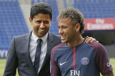 Brazilian soccer star Neymar walks away with the chairman of Paris Saint-Germain Nasser Al-Khelaifi, left, following a press conference in Paris Friday, Aug. 4, 2017. Neymar arrived in Paris on Friday the day after he became the most expensive player in soccer history when completing his blockbuster transfer to Paris Saint-Germain from Barcelona for 222 million euros ($262 million). (AP Photo/Michel Euler)