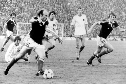 Scotland's Graeme Souness (l) and Kenny Dalglish (r) watch as teammate Archie Gemmill (c) looks up to pick his spot before bending in his team's third goal