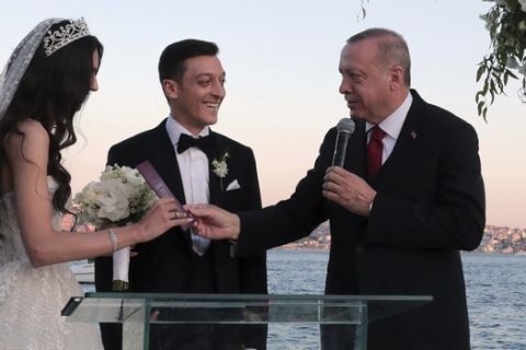 Turkey's President Recep Tayyip Erdogan speaks to Turkish-German soccer player Mesut Ozil and his wife Amine Gulse during a wedding ceremony over the Bosporus in Istanbul, Friday, June 7, 2019. Erdogan's wife Emine Erdogan is at right. (Presidential Press Service via AP, Pool)