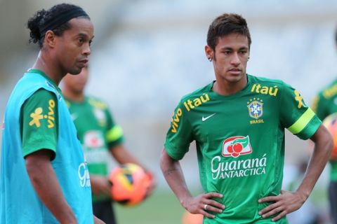 Brazil's Neymar, right, and Ronaldinho isten to coaching instructions during a training session in Belo Horizonte, Brazil, Tuesday, April 23, 2013. Brazil will play a friendly soccer match against Chile on Wednesday. (AP Photo/Andre Penner)