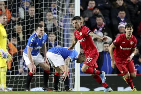 Leverkusen's Charles Aranguiz, center, celebrates after scoring his side's second goal during the Europa League round of 16 first leg soccer match between Rangers and Bayer Leverkusen at the Ibrox stadium in Glasgow, Scotland, Thursday, March 12, 2020. (AP Photo/Scott Heppell)