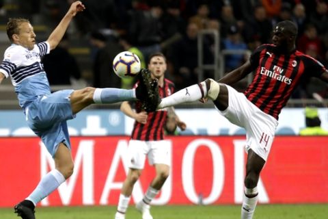 Lazio's Lucas Leiva, left, and AC Milan's Tiemoue Bakayoko challenge for the ball during the Serie A soccer match between AC Milan and Lazio, at the San Siro stadium in Milan, Italy, Saturday, April 13, 2019. (AP Photo/Luca Bruno)
