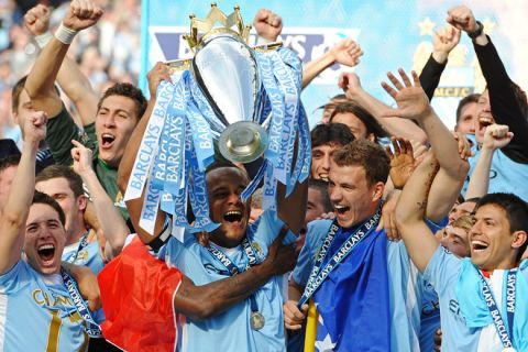 Manchester City's Belgian captain Vincent Kompany lifts the Premier league trophy, and celebrates with Bosnian striker Edin Dzeko (2nd R), Argentinian striker Sergio Aguero (R) and French midfielder Samir Nasri (L) after their 3-2 victory over Queens Park Rangers in the English Premier League football match between Manchester City and Queens Park Rangers at The Etihad stadium in Manchester, north-west England on May 13, 2012. Manchester City won the game 3-2 to secure their first title since 1968. This is the first time that the Premier league title has been decided on goal-difference, Manchester City and Manchester United both finishing on 89 points. AFP PHOTO/PAUL ELLIS

RESTRICTED TO EDITORIAL USE. No use with unauthorized audio, video, data, fixture lists, club/league logos or 'live' services. Online in-match use limited to 45 images, no video emulation. No use in betting, games or single club/league/player publications.PAUL ELLIS/AFP/GettyImages