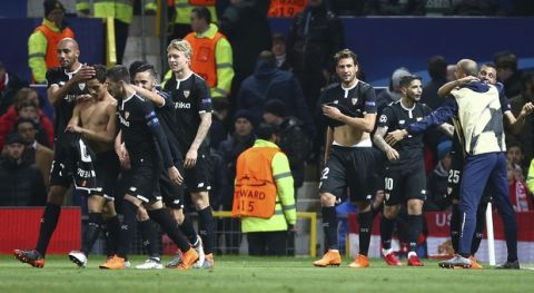 Sevilla's Wissam Ben Yedder, second left puts his shirt back on as he celebrates with teammates after scoring his sides second goal during the Champions League round of 16 second leg soccer match between Manchester United and Sevilla, at Old Trafford in Manchester, England, Tuesday, March 13, 2018. (AP Photo/Dave Thompson)