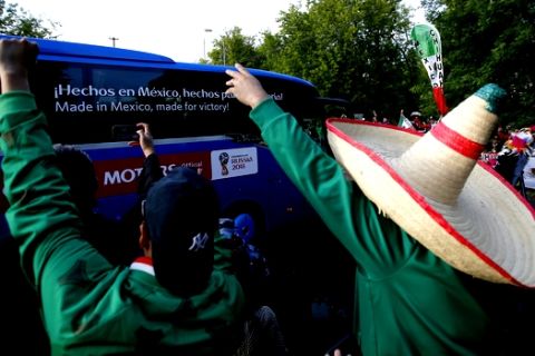A Mexico fan wearing a tradition Mexican hat, cheers as his team, the Mexico national soccer team, boards a bus after training session at the 2018 soccer World Cup, in Moscow, Russia, Tuesday, June 12, 2018. (AP Photo/Eduardo Verdugo)