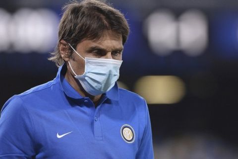 Inter Milan coach Antonio Conte walks off the pitch at half-time, during the Italian Cup second leg semifinal soccer match between Napoli and Inter Milan, at the Naples San Paolo Stadium, Italy, Saturday, June 13, 2020. The match is being played without spectators because of the COVID-19 restriction measures. (Cafaro/LaPresse via AP)