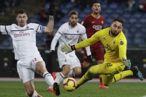 AC Milan goalkeeper Gianluigi Donnarumma makes a save ahead of his teammate Alessio Romagnoli, left, during the Serie A soccer match between Roma and AC Milan, at the Olympic Stadium in Rome, Sunday, Feb. 3, 2019. (AP Photo/Gregorio Borgia)