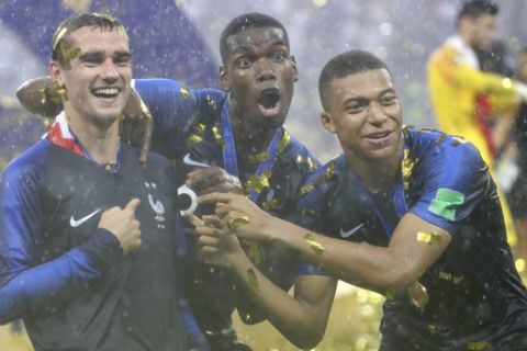 France's Antoine Griezmann, points to two stars on his jersey indicating two world cup wins, as he celebrates with Paul Pogba and Kylian Mbappe after the final match between France and Croatia at the 2018 soccer World Cup in the Luzhniki Stadium in Moscow, Russia, Sunday, July 15, 2018. France won the final 4-2. (AP Photo/Matthias Schrader)