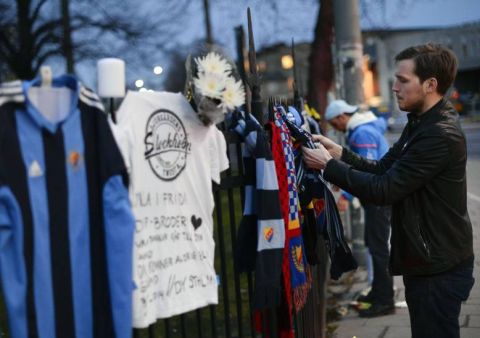 Supporters of different football clubs pay their respects outside Stockholms Stadion, laying down flowers and jerseys, after a Djurgarden IF supporter got assaulted and died of his head injuries before the season opening Swedish league match between Helsingborg IF and Djurgarden IF held at Olympia in Helsingborg on March 30, 2014.     TOPSHOTS/AFP PHOTO/JONATHAN NACKSTRAND