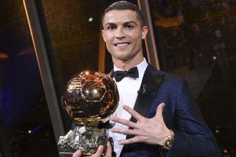 CORRECTS SPELLING OF THE NAME - This image provided by L'Equipe Friday Dec. 8, 2017 shows Portuguese soccer player Cristiano Ronaldo holding the Ballon d' Or (Golden Ball) he received Thursday Dec. 7, 2017 in Paris. A decade of dominance as the world's two best soccer players has left Cristiano Ronaldo and Lionel Messi level with five Ballon d'Or awards each. (Franck Faugere, L'Equipe, via AP)