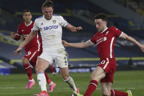 Liverpool's Diogo Jota, right, is challenged by Leeds United's Luke Ayling during the English Premier League soccer match between Leeds United and Liverpool at the Elland Road stadium in Leeds, England, Monday, April 19, 2021. (Lee Smith/Pool via AP)