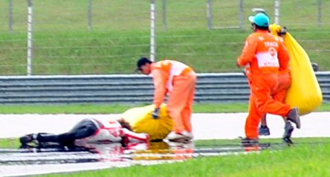 Race marshalls attend to Honda rider Marco Simoncelli (L) of Italy following a fatal crash four minutes after the start of the Malaysian MotoGP race in Sepang on October 23, 2011. Italy's Marco Simoncelli died of injuries sustained in the crash that resulted in the cancellation of the Malaysian MotoGP, in the latest tragedy to hit motor sports. AFP PHOTO (Photo credit should read STR/AFP/Getty Images)