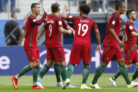 Portugal's Cristiano Ronaldo, left, celebrates after scoring his side's first goal during the Confederations Cup, Group A soccer match between New Zealand and Portugal, at the St. Petersburg Stadium, Russia, Saturday, June 24, 2017. (AP Photo/Pavel Golovkin)