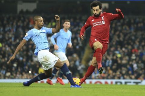 Manchester City's Fernandinho, left, is challenged by Liverpool's Mohamed Salah during their English Premier League soccer match between Manchester City and Liverpool at the Ethiad stadium, Manchester England, Thursday, Jan. 3, 2019. (AP Photo/Jon Super)