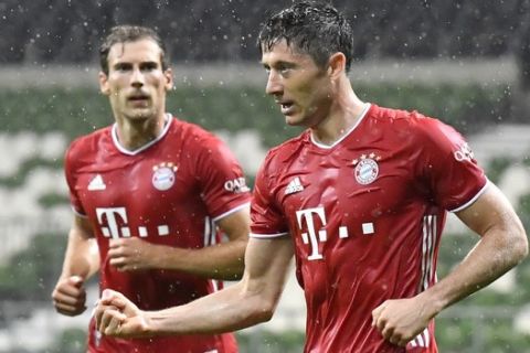 Bayern's Robert Lewandowski, right, celebrates after scoring his side's opening goal during the German Bundesliga soccer match between Werder Bremen and Bayern Munich in Bremen, Germany, Tuesday, June 16, 2020. Because of the coronavirus outbreak all soccer matches of the German Bundesliga take place without spectators. (AP Photo/Martin Meissner, Pool)