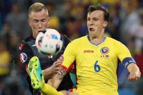 Romania's Vlad Chiriches, right, and Albania's Arlind Ajeti fight for the ball during the Euro 2016 Group A soccer match between Romania and Albania at the Grand Stade in Decines-­Charpieu, near Lyon, France, Sunday, June 19, 2016. (AP Photo/Laurent Cipriani)