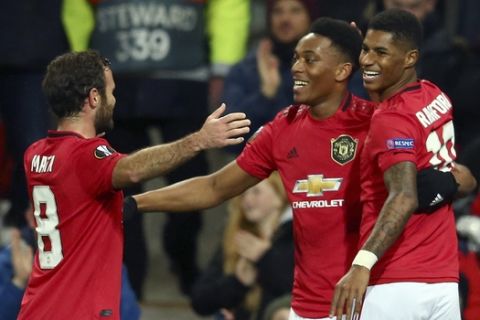 Manchester United's Anthony Martial, center, celebrates with Juan Mata and Marcus Rashford, right, after scoring his side's second goal during the Europa League group L soccer match between Manchester United and FK Partizan at Old Trafford Stadium in Manchester, England, Thursday, Nov. 7, 2019. (AP Photo/Dave Thompson)